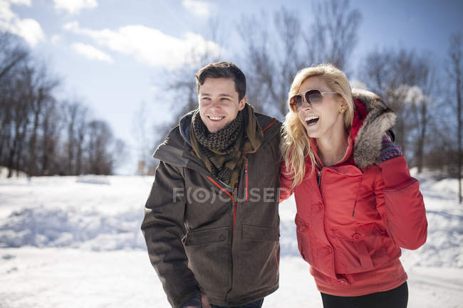 Кавказская пара обнимается и смеется зимой — стоковое фото