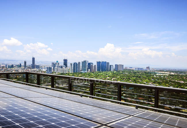 Paneles solares y paisaje urbano de Manila bajo el cielo azul, Filipinas - foto de stock