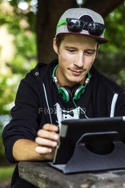 Homem caucasiano usando tablet digital ao ar livre — Fotografia de Stock