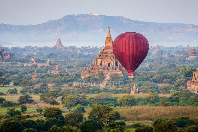 Globos de aire caliente volando sobre antiguas torres de stupa en Yangón, Myanmar, Asia - foto de stock