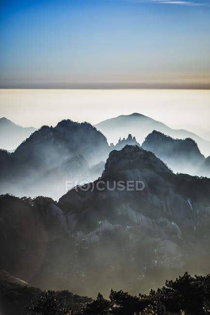 Nevoeiro rolando sobre montanhas rochosas, Huangshan, Anhui, China , — Fotografia de Stock