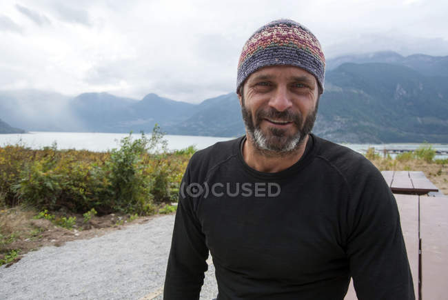Smiling mature man wearing beanie hat outdoors — Stock Photo