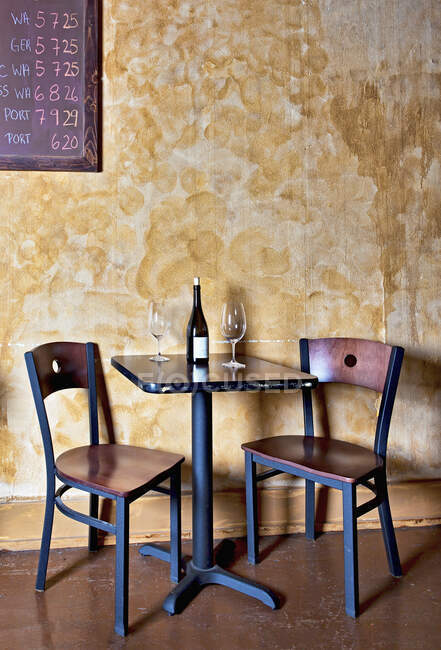 Bottle of wine and glasses on table in wine bar — Stock Photo