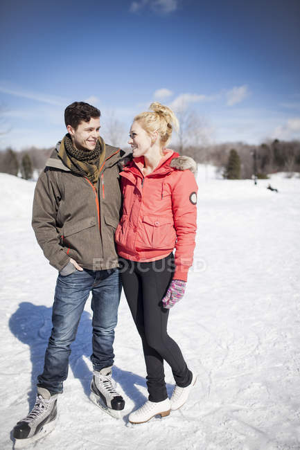 Jeune couple patinage sur glace sur lac gelé en hiver — Photo de stock