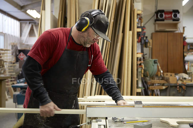 Carpinteiro usando serra de mesa no interior da oficina — Fotografia de Stock
