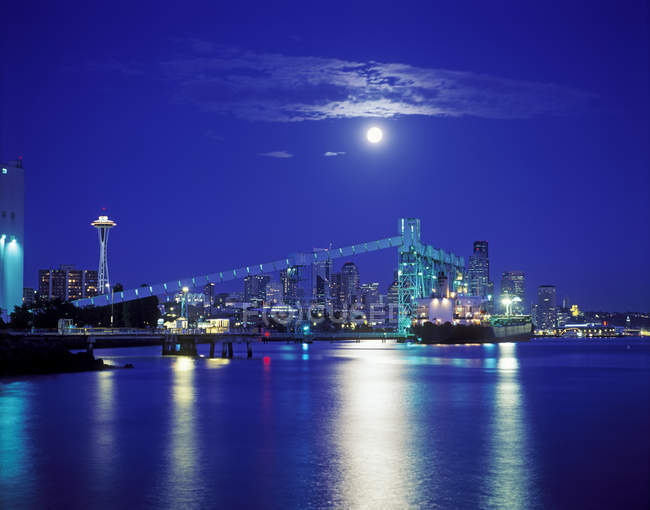Luna sobre horizonte iluminado de la ciudad de Seattle en la noche, Washington, Estados Unidos - foto de stock
