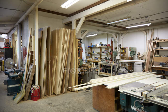 Дерево, рабочие скамейки и инструменты в интерьере мастерской — стоковое фото