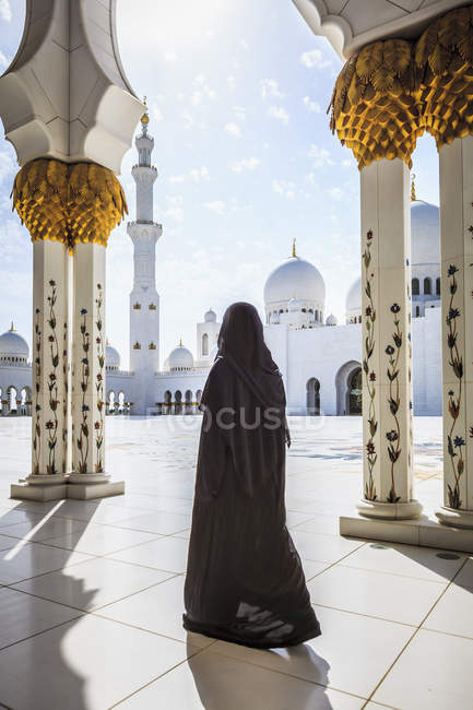Femme marchant à la Grande Mosquée Cheikh Zayed, Abu Dhabi, Émirats Arabes Unis — Photo de stock