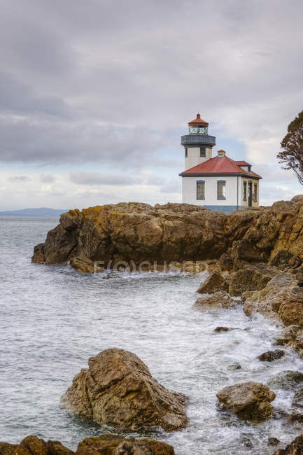 Lighthouse overlooking rocky coastline at Admiralty Inlet, Washington, USA — Stock Photo