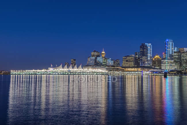 Skyline frente al mar iluminado por la noche, Vancouver, Columbia Británica, Canadá , - foto de stock