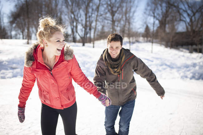 Jeune couple patinage sur glace sur lac gelé en hiver — Photo de stock