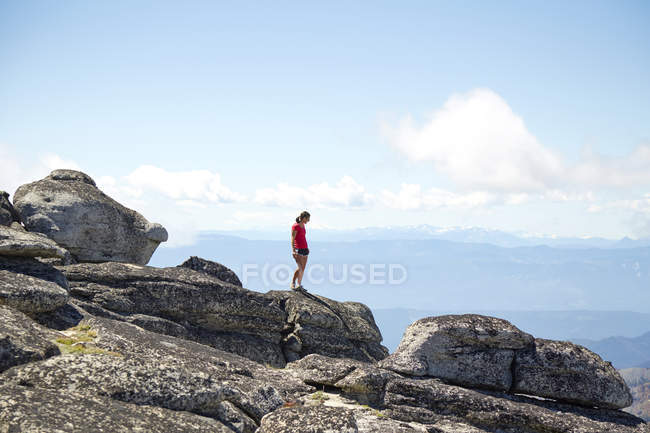 Caminhante em pé no topo da colina em paisagem remota — Fotografia de Stock