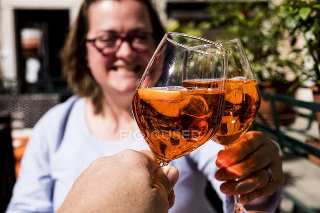 Woman sitting at table and toasting with wine glasses of alcoholic drink with man. — Stock Photo