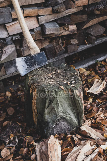 High angle close-up of axe on chopping block, scattered wood cuttings and autumn leaves. — Stock Photo