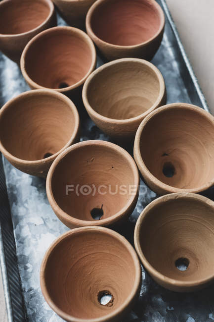 High angle close-up of terracotta plant pots on metal tray. — Stock Photo