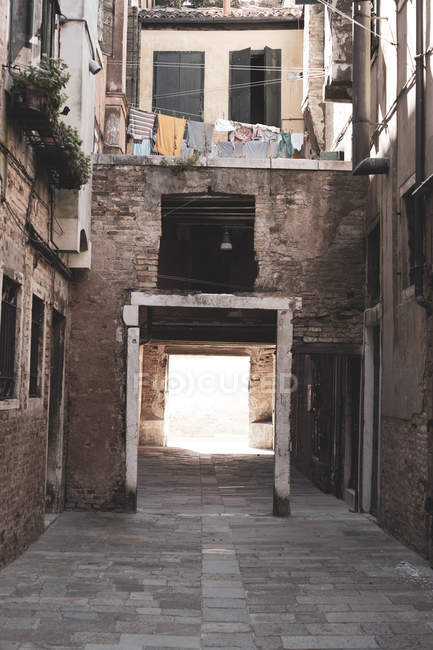 Callejón estrecho con edificios residenciales y puerta de entrada en Venecia, Véneto, Italia . - foto de stock