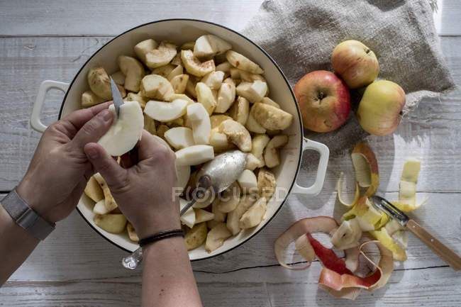 Primer plano de la mujer colocando manzanas en lata redonda para hornear . - foto de stock