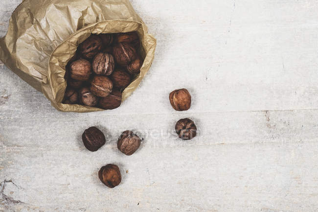 Primer plano en ángulo alto de la bolsa de papel marrón con nueces frescas . - foto de stock