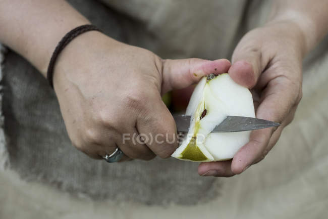 Primo piano della donna peeling mela con coltello . — Foto stock