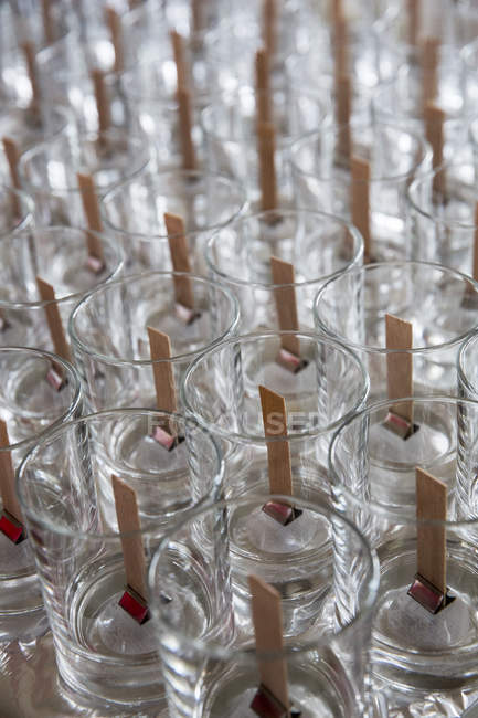 Primer plano de ángulo alto de frascos de vidrio vacíos con mechas de madera para hacer velas
. - foto de stock