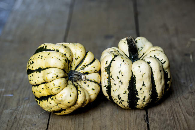 High angle view of two sweet dumpling squashes on rustic wooden table. — Stock Photo