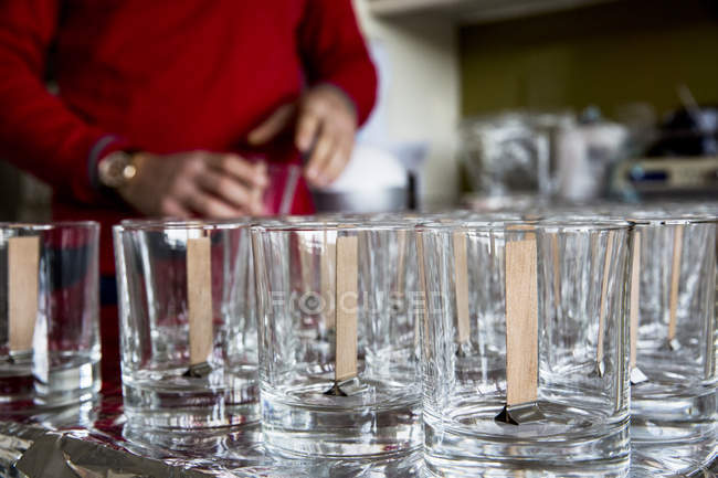 Primer plano de frascos de vidrio vacíos con mechas de madera para hacer velas . - foto de stock