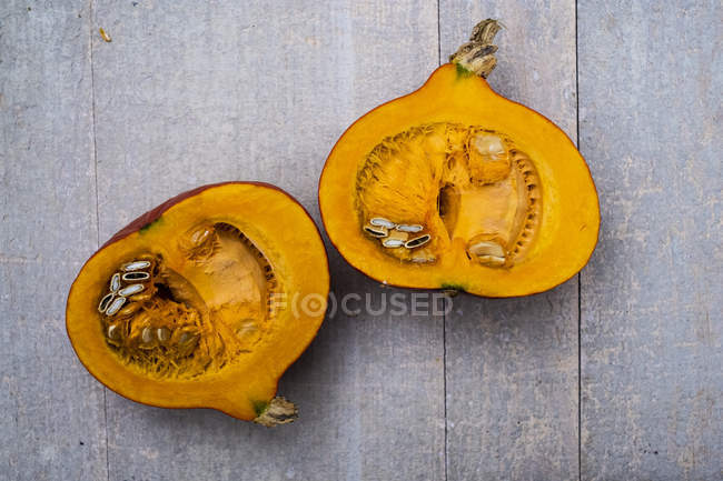 High angle view of red pumpkin with orange flesh cut in half. — Stock Photo