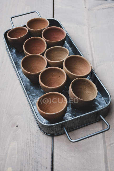 Primo piano ad angolo alto di vasi di terracotta su vassoio di metallo . — Foto stock