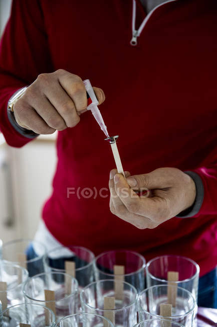 Man standing in domestic kitchen and making jar candles. — Stock Photo