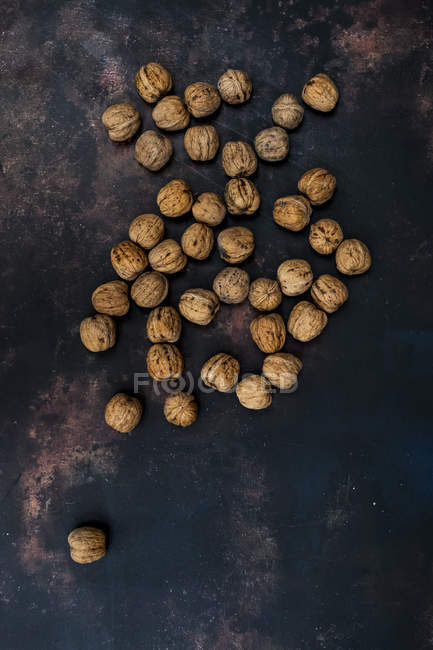 Вид сверху на грецкие орехи на черной ржавой поверхности стола . — стоковое фото