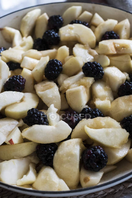Close-up of round baking tin with apples and blackberries. — Stock Photo