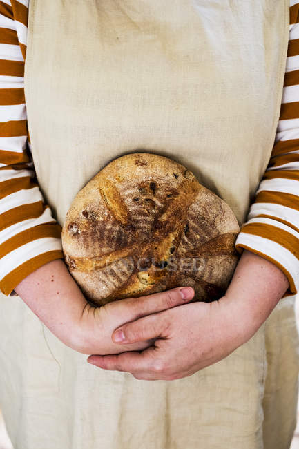 Close-up of person holding freshly baked round loaf of bread. — Stock Photo