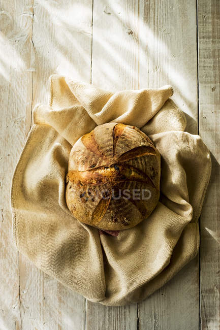 Vue de dessus du pain rond fraîchement cuit sur un torchon . — Photo de stock