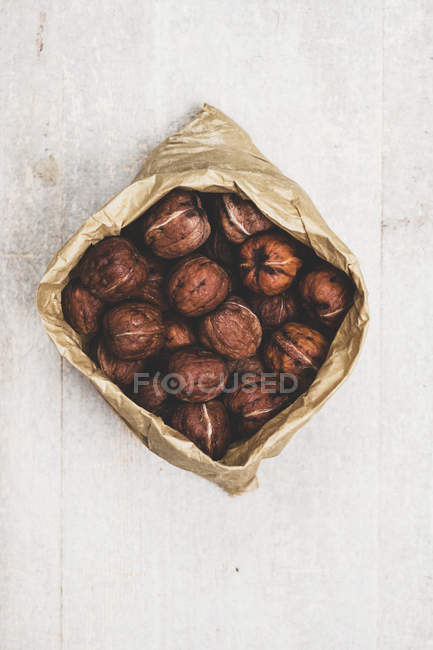 Крупный план коричневого бумажного пакета со свежими грецкими орехами . — стоковое фото