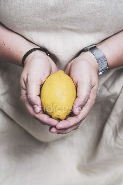 Close up of person hands holding fresh lemon. — Stock Photo
