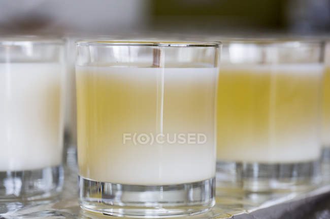 Close-up of handmade white and yellow jar candles with wooden wick. — Stock Photo