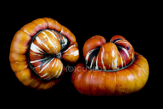 Close-up of two orange Turban pumpkins on black background. — Stock Photo