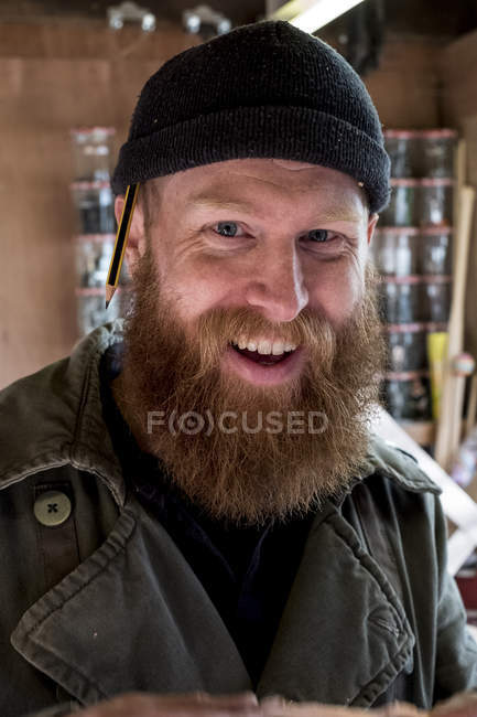 Portrait of smiling bearded man with brown hair, wearing black beanie. — Stock Photo