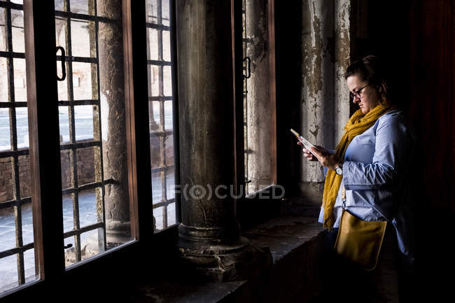 Woman in glasses standing at windows of historic building in Venice, Veneto, Italy. — Stock Photo