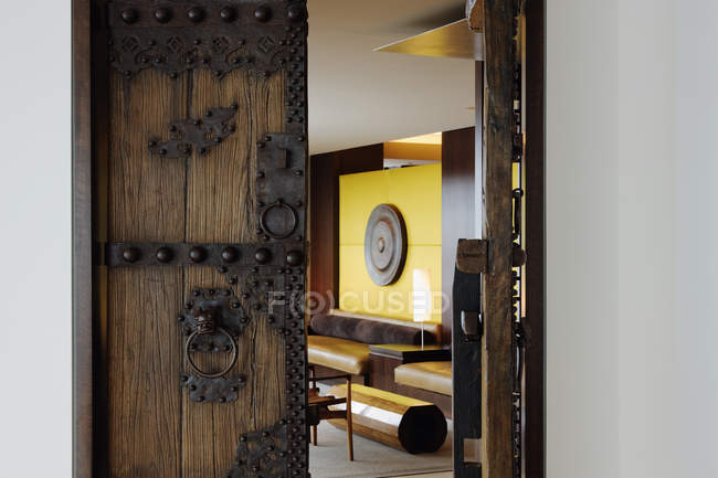 Open wooden ornate door to living room of house — Stock Photo
