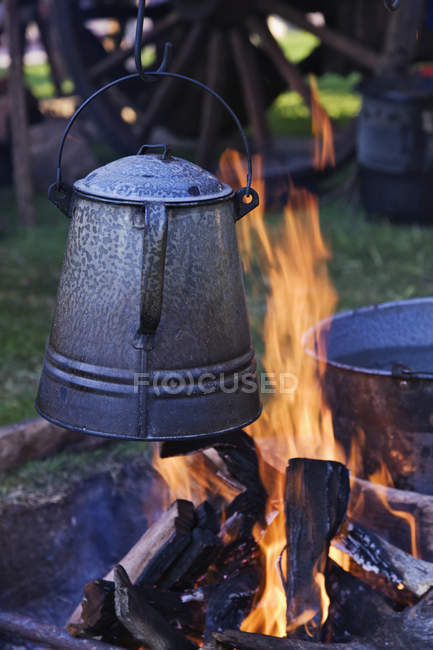 Кофейник на открытом огне с бревнами, крупным планом — стоковое фото