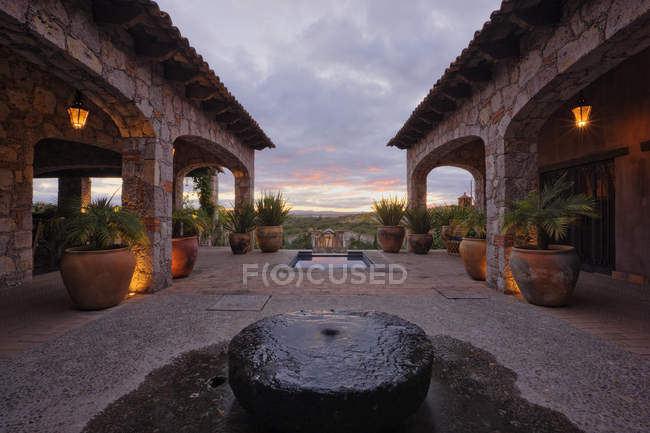 Mexican ranch house yard with fountain and succulents in pots — Stock Photo