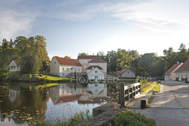 Edifici che si affacciano sulla calma acqua del laghetto di Vihula Manor, Vihula, Estonia — Foto stock