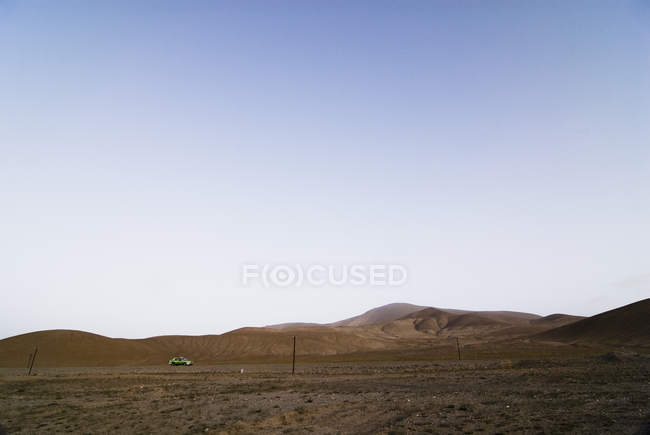 Taxi vehicle moving in rural hilly landscape, Karakoram highway, Xinjiang, China — Stock Photo