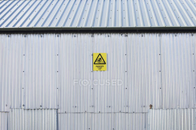 Warnschild an altem Industriegebäude — Stockfoto