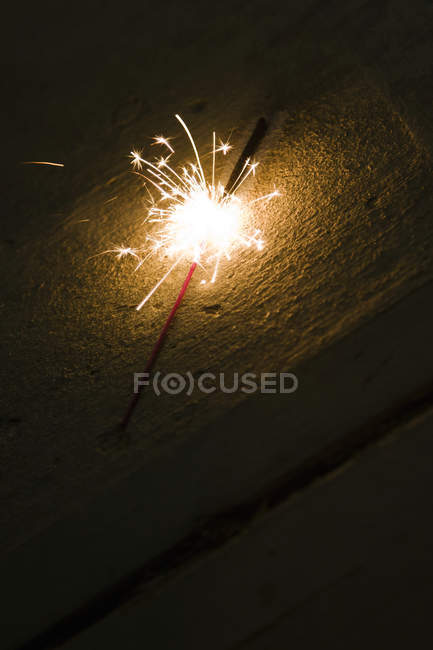 Close-up of firework sparkler on sandy beach. — Stock Photo