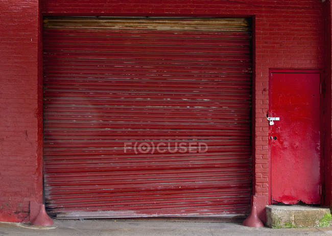 Red loading bay door in red brick building — Stock Photo