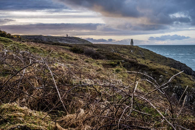 Cardigan Bay con pietra lontana cairn marcatura ingresso al porto di Porthgain dal Pembrokeshire Coast Trail, Pembrokeshire National Park, Galles, Regno Unito
. — Foto stock