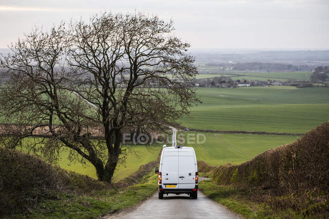 Rear view of camper van driving down country lane. — Stock Photo