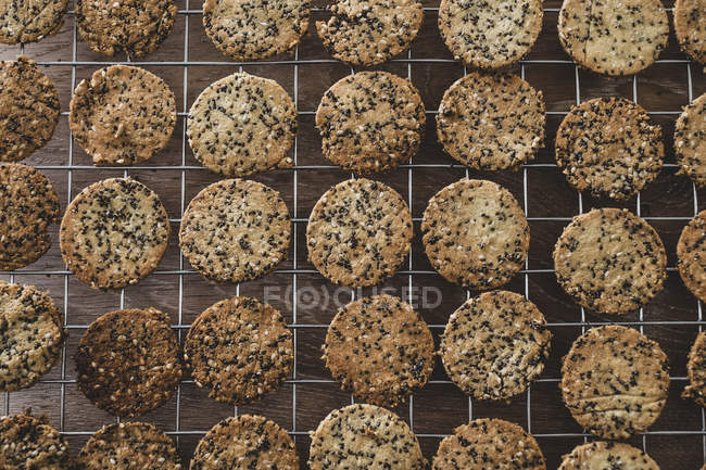 Visão de alto ângulo de biscoitos semeados recém-assados no rack de refrigeração . — Fotografia de Stock